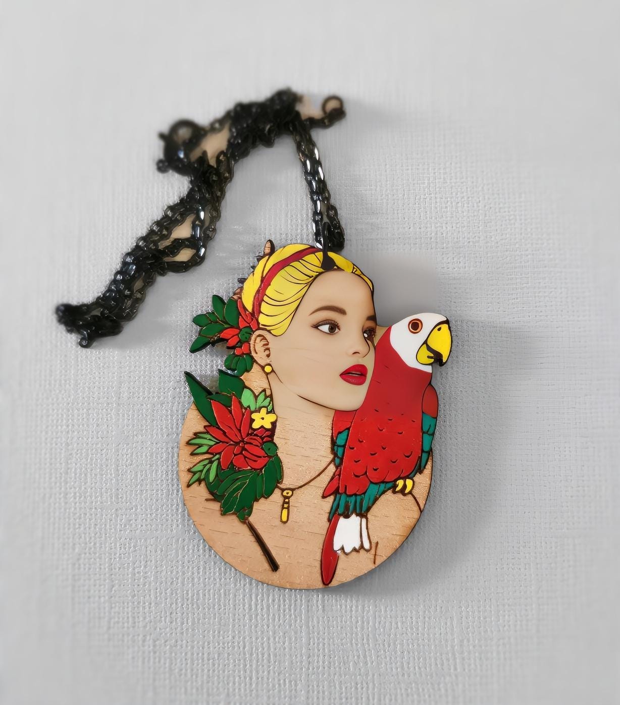 Pendentif gravé et découpé dans l'esprit Frida Kahlo, perroquet sur l'épaule d'une femme