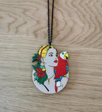 Pendentif gravé et découpé dans l'esprit Frida Kahlo, perroquet sur l'épaule d'une femme