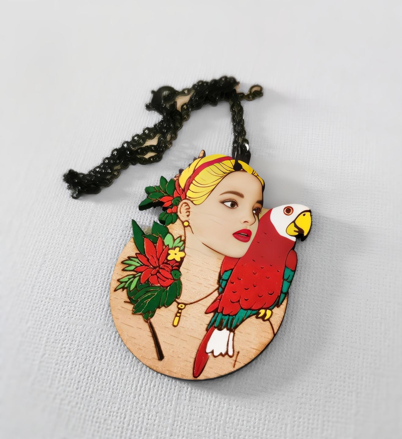 Pendentif gravé et découpé dans l'esprit Frida Kahlo, perroquet sur l'épaule d'une femme