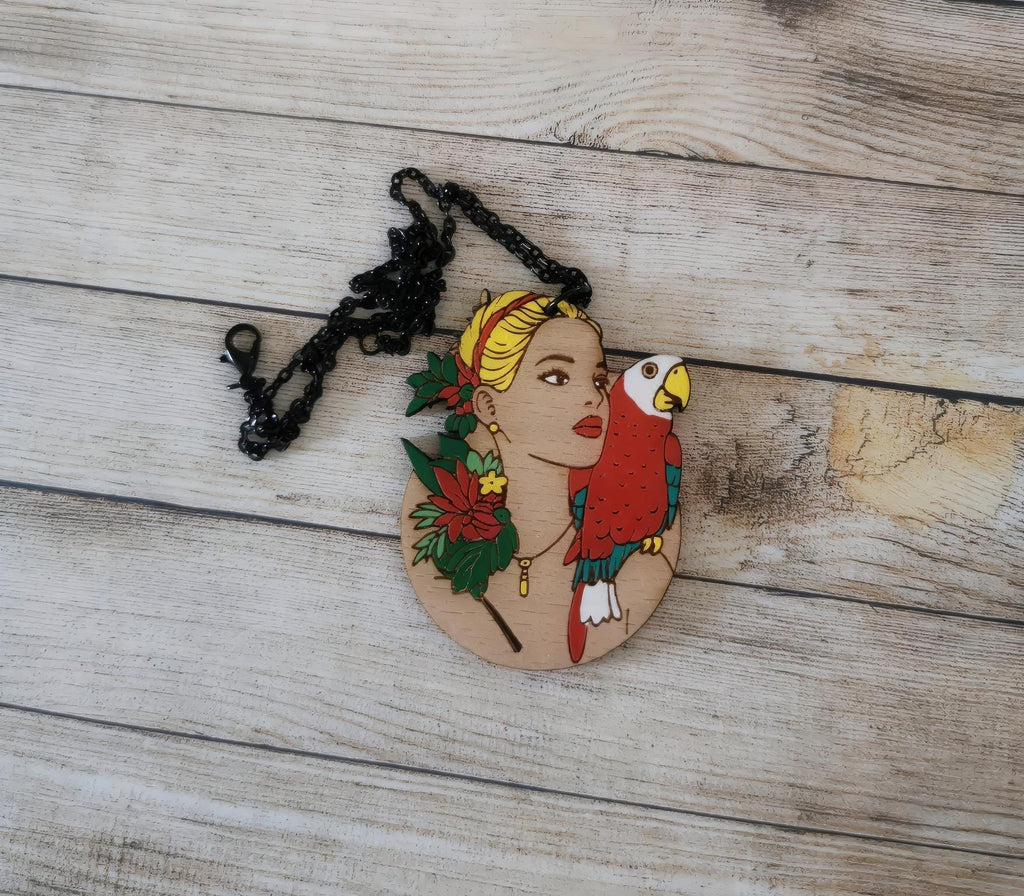 Pendentif gravé et découpé dans l'esprit Frida Kahlo, perroquet sur l'épaule d'une femme