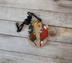 Pendentif gravé et découpé dans l'esprit Frida Kahlo, perroquet sur l'épaule d'une femme