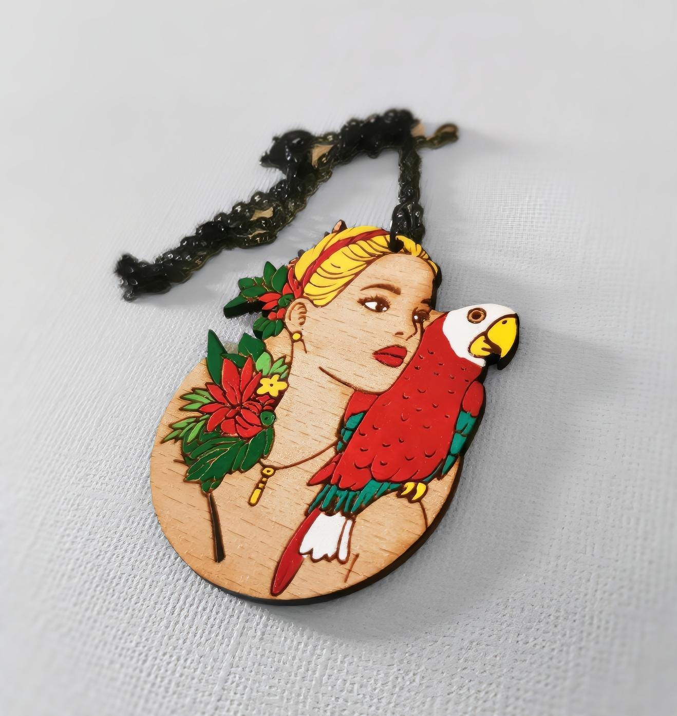 Pendentif gravé et découpé dans l'esprit Frida Kahlo, perroquet sur l'épaule d'une femme