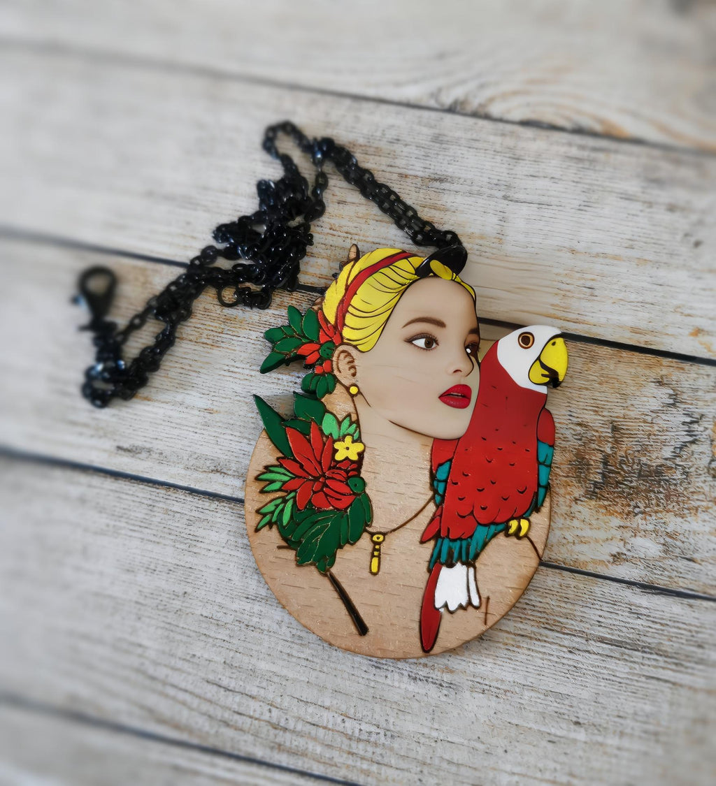 Pendentif gravé et découpé dans l'esprit Frida Kahlo, perroquet sur l'épaule d'une femme