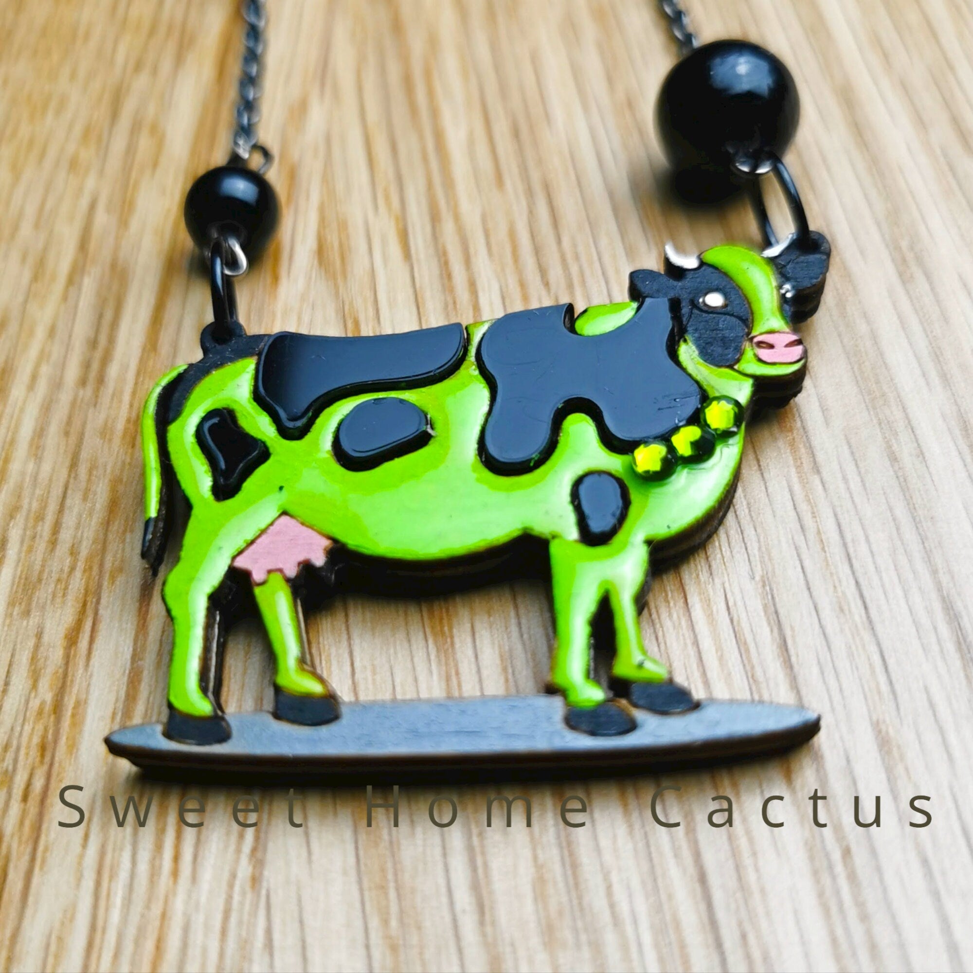 Pendentif Vache Verte, découpe de bois au laser, peinture et srass
